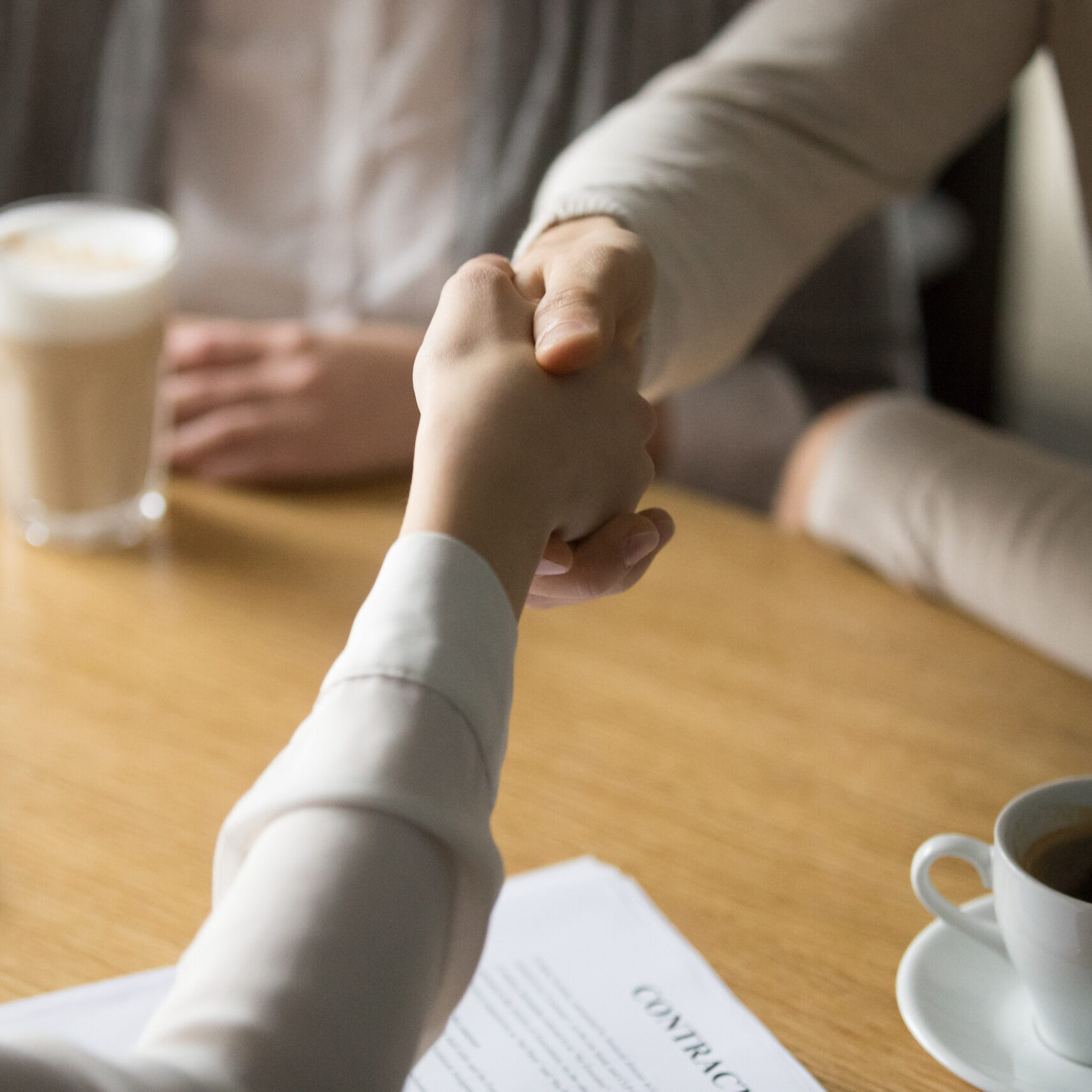 Couple handshaking businesswoman making investment deal in cafe, clients customers agree to sign contract shaking hands with mortgage insurance broker, estate agent or lawyer, close up view
